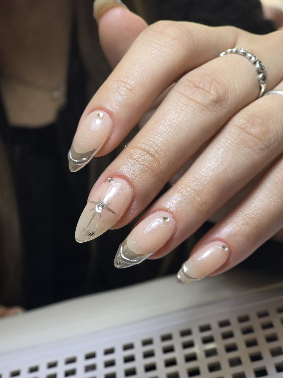 Nail art nude con puntas cromadas y detalles de estrellas